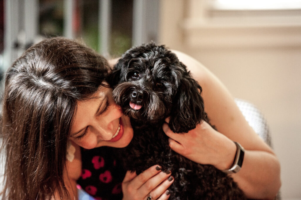 This is a photo by Tonya Dean Photography of Kat Stano snuggling with her dog Cosette.