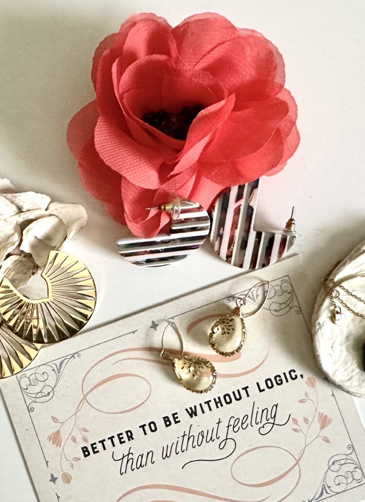 This is a photo by Kat Stano of Starfish Project jewelry, two seashells, a flower, and a Jane Austen quote that says, "Better to be without logic than without feeling."