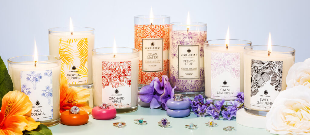 The is a photo of Jewel Scent candles with beautiful gemstone rings displayed with them.