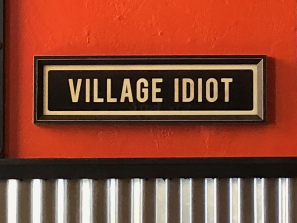 Here's a sign from a restaurant that says "Village Idiot" as an example of what not to say for comebacks to rude comments.