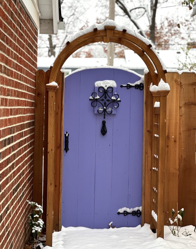 This is the secret garden door in the snow as a magical garden fantasy example.