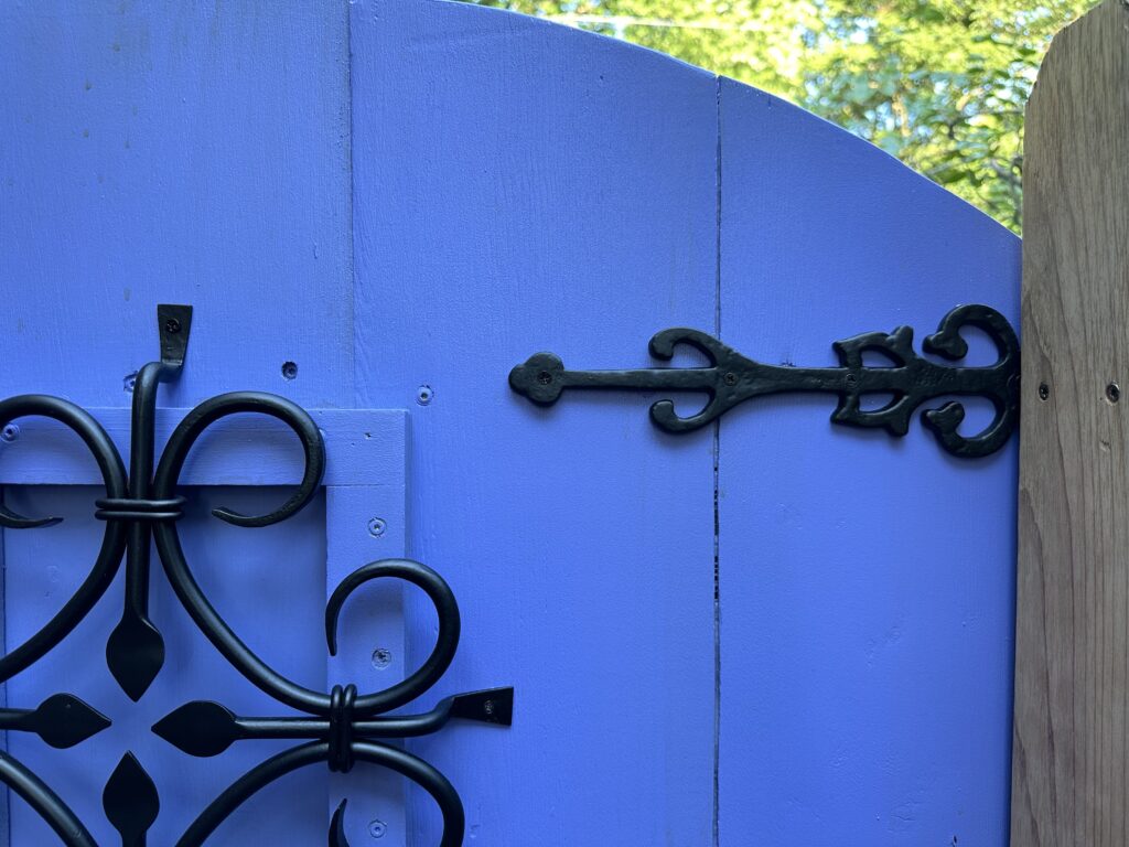 This is a closeup of Kat's secret garden gate with a speakeasy grille and ornate hardware.