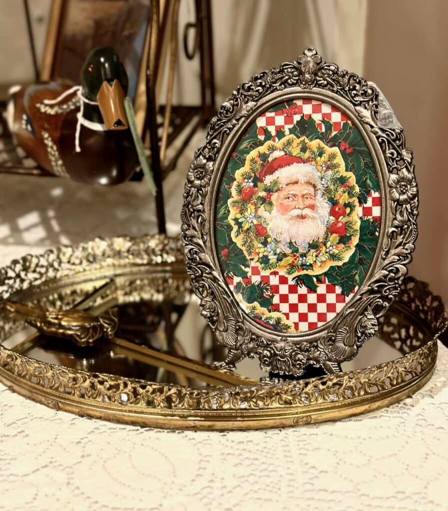 This is a Santa greeting card or gift wrap framed in a fancy silver frame for christmas diys easy. There's also a mirrored tray and duck figurine.