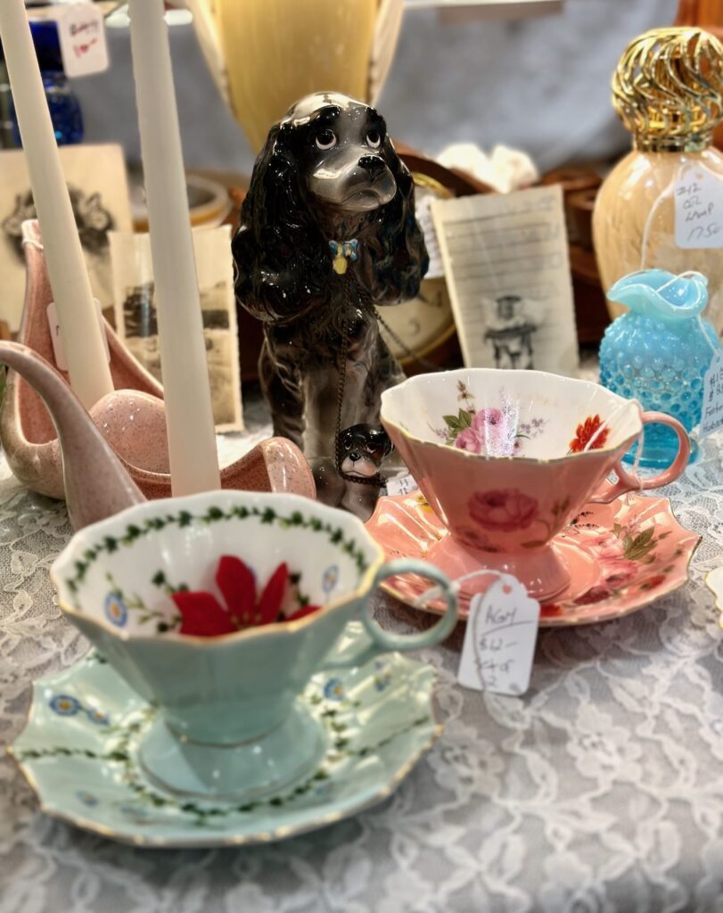 Here are some antique teacups by some old perfume bottles and a poodle figurine to illustrate christmas gift container ideas.