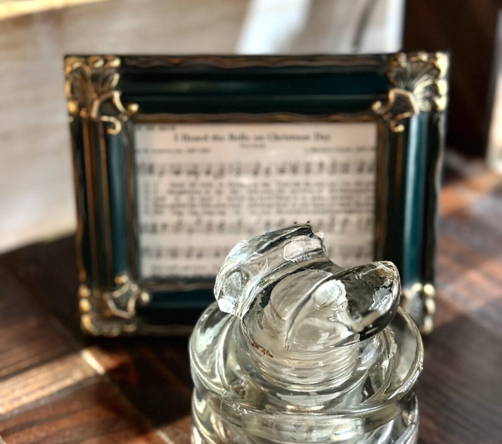 This is a framed Christmas carol with a crystal container to represent christmas music lists.