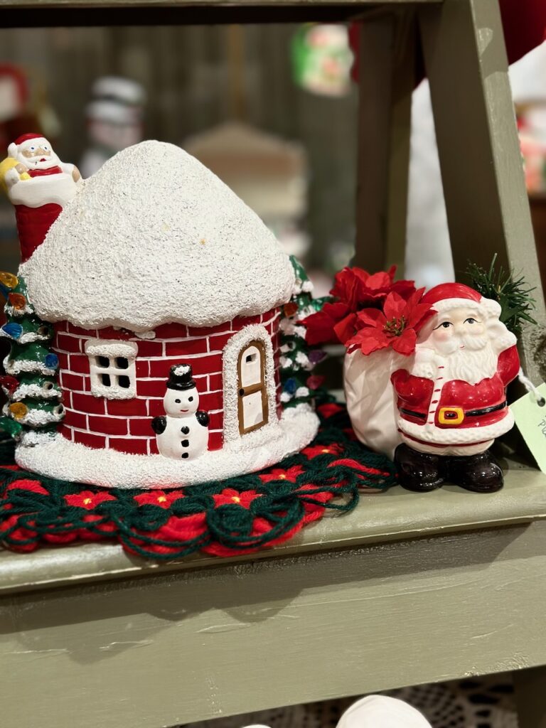 Here's a decorative ladder with a Santa figurine and a little house figurine with Santa in the chimney top for christmas outdoor arrangements ideas.