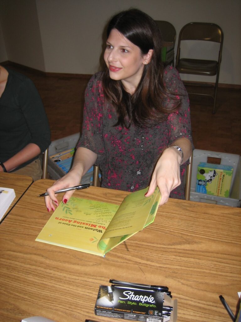 This is Kat Stano writing in one of her children's books at a book signing.