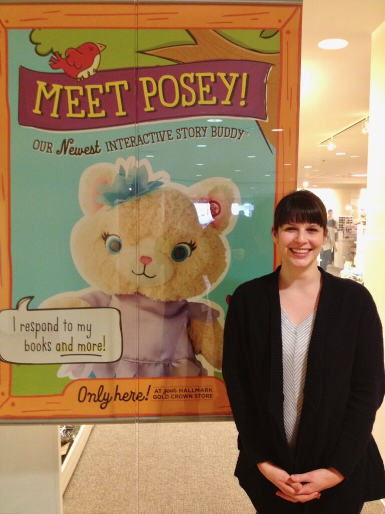 This is kat stano writing standing in front of her Posey book poster.