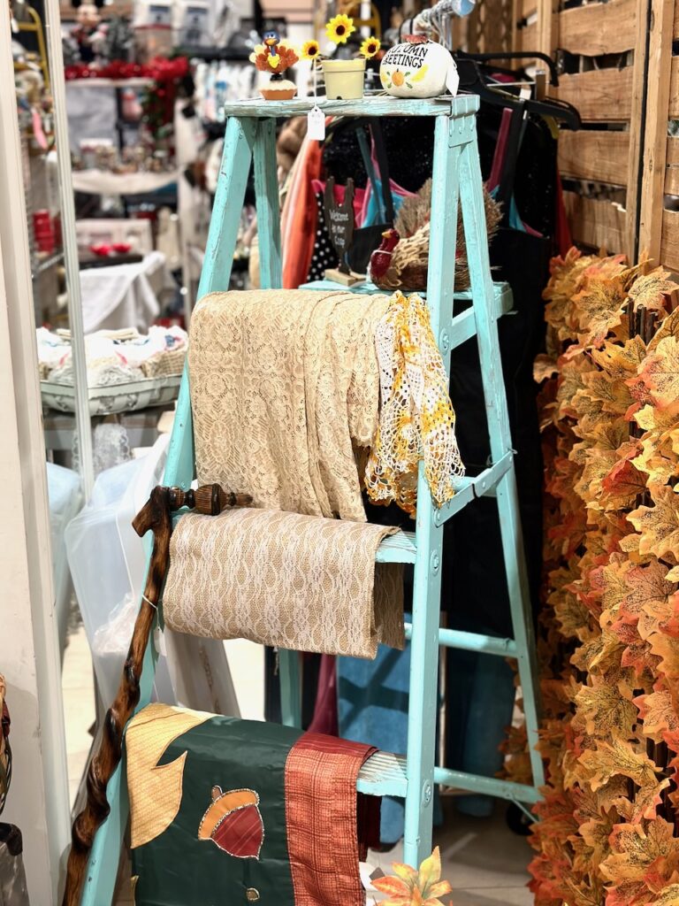 Here's a colorful seafoam green ladder with festive blankets draped over the rungs as ideas for shopping for christmas decor.