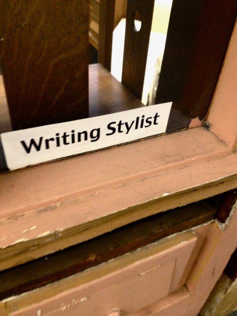 This is a sign at Kat's old desk that says "Writing Stylist" to inspire a word of the year generator.