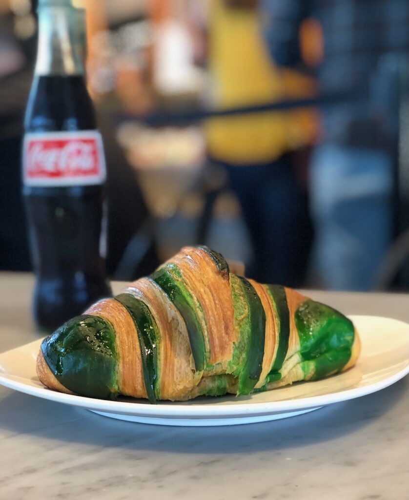 This is a pistachio croissant and a Coke bottle at a restaurant to talk about characteristics of a soft hearted person.