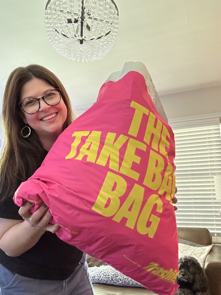 This is Kat holding a full Trashie bag with her dog in the background as an example of environmentally friendly wedding favours.