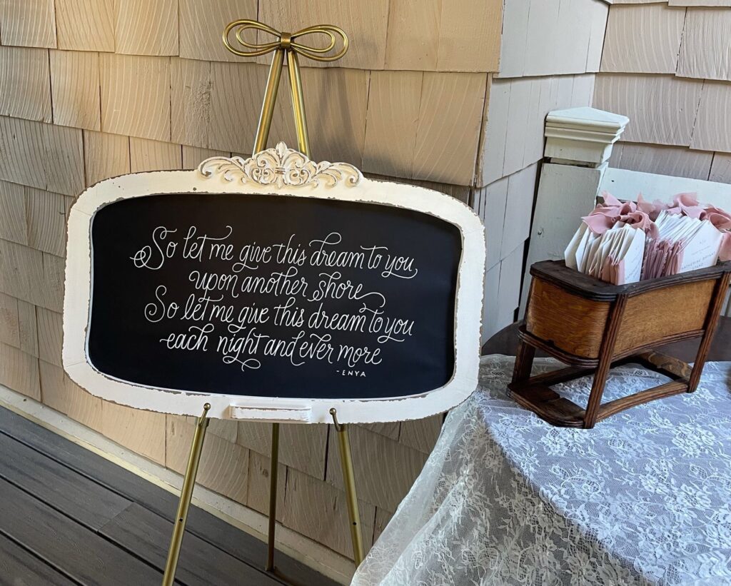 This is an Enya quote professionally lettered by Kat's friend at her wedding to talk about what are good wedding favors. The quote is, "So let me give this dream to you upon another shore.So let me give this dream to you each night and evermore."