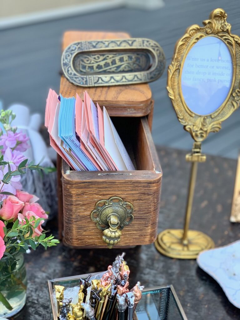 This is a pic from Kat's wedding with an antique letters mail slot, framed instructions, cards in an old Singer sewing machine drawer, flowers, and pens in a makeup holder to show environmentally friendly wedding ideas.