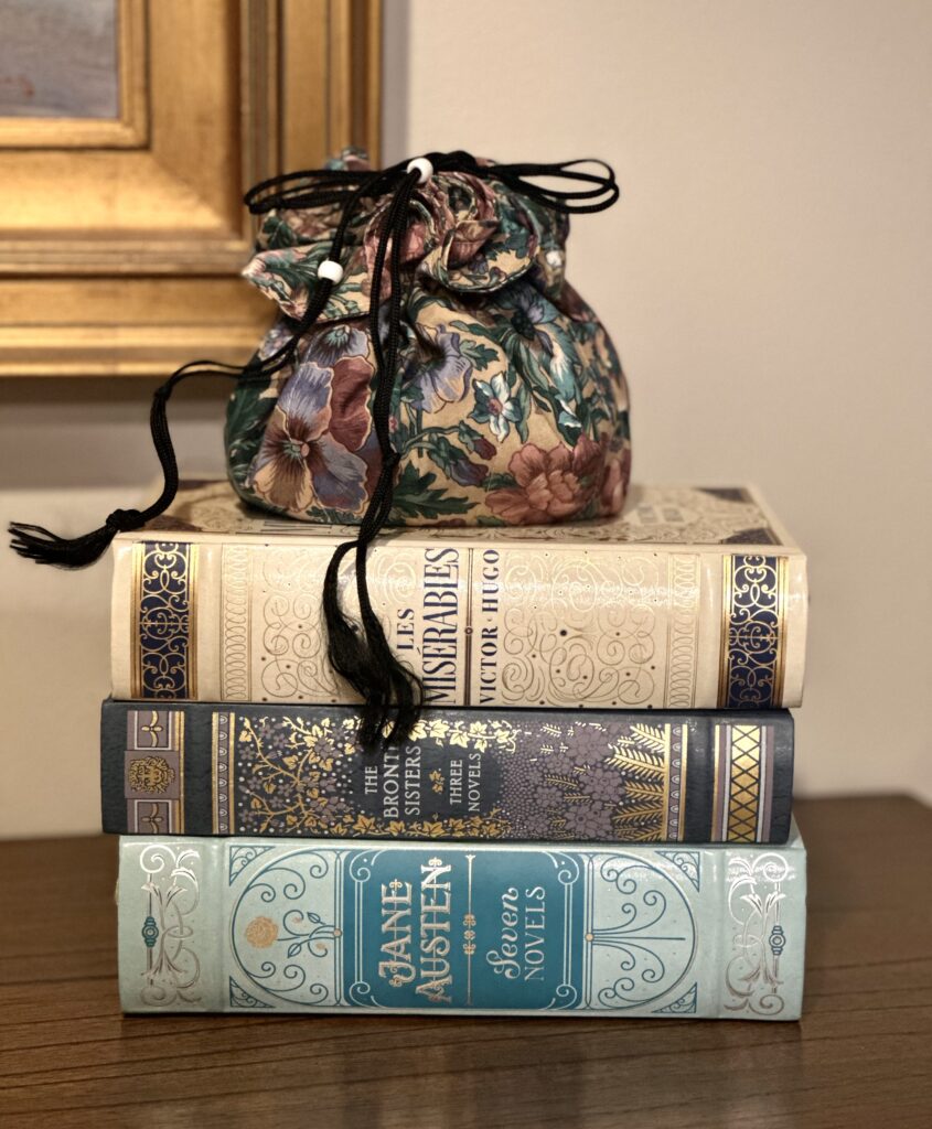 This is a pretty jewelry pouch sitting on top of classic novels to represent cloth ice pack covers.