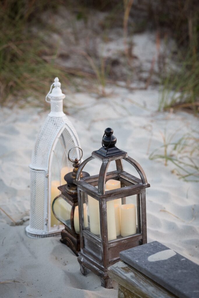 These are lanterns sitting on the beach sand to talk about wedding send off ideas not sparklers.