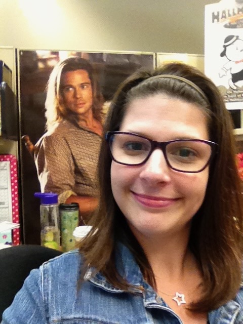 This is Kat sitting at her desk with a Brad Pitt poster displayed behind her to show retro ideas including diy business card holder.