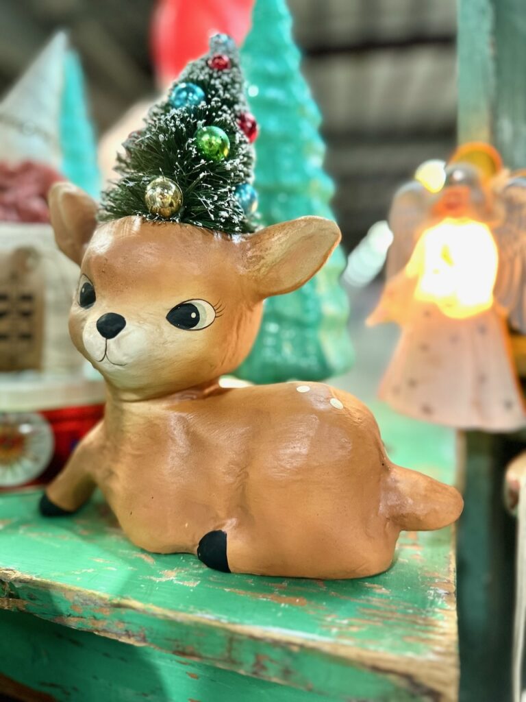 This is a cute vintage deer figurine with a Christmas tree on its head to show eco decorations.