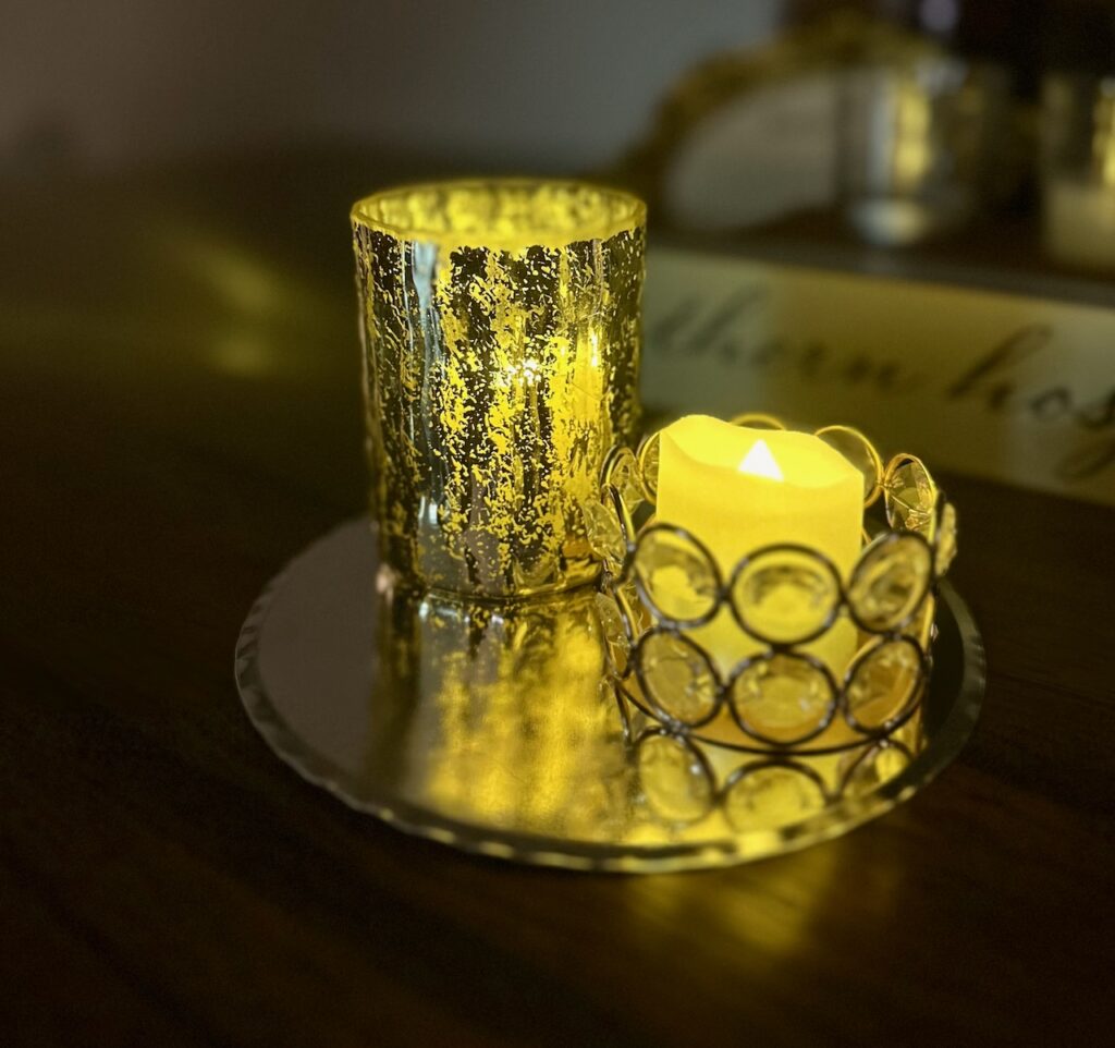 These are flameless candles in pretty votives sitting on a coffee tin cutout to show easy sustainable christmas decorations.