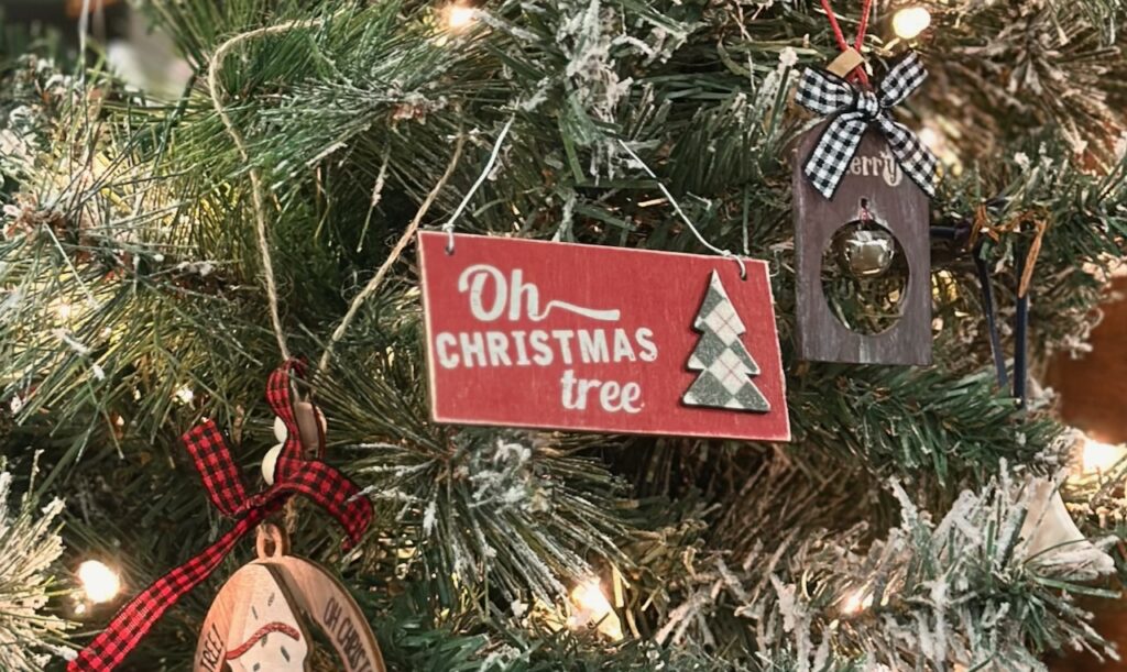 These are wooden ornaments on a lighted tree with one that says, "Oh Christmas tree" to show fair trade christmas ornaments.
