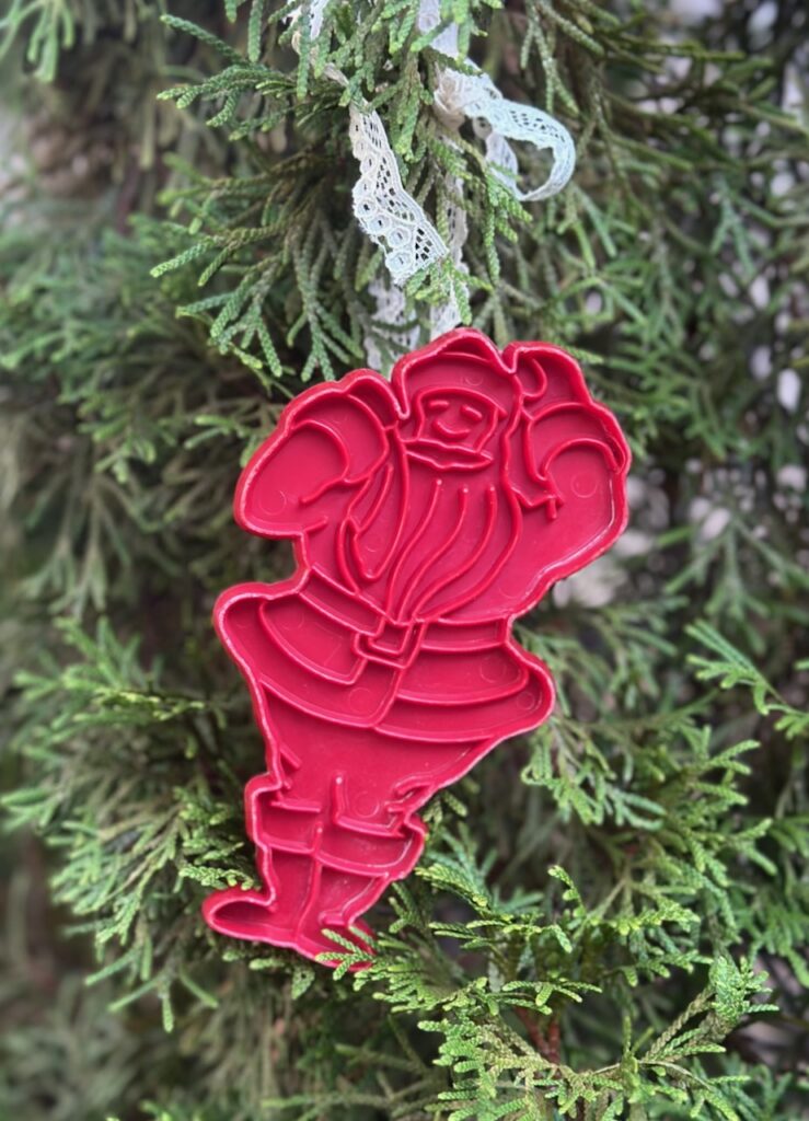 This is an eighties Santa cookie cutter with a lace ribbon hanging on the tree to show recycled christmas baubles.