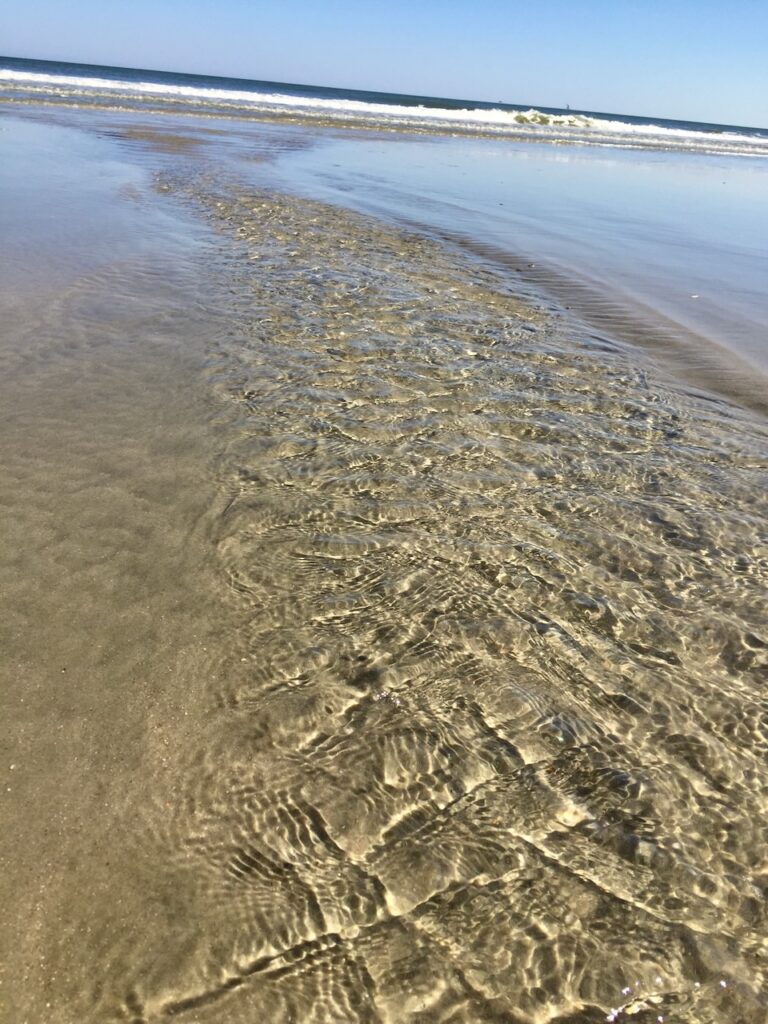 This is the ocean shore with beautiful sand ripples to start a conversation about how long does plastic take to decompose in the ocean.