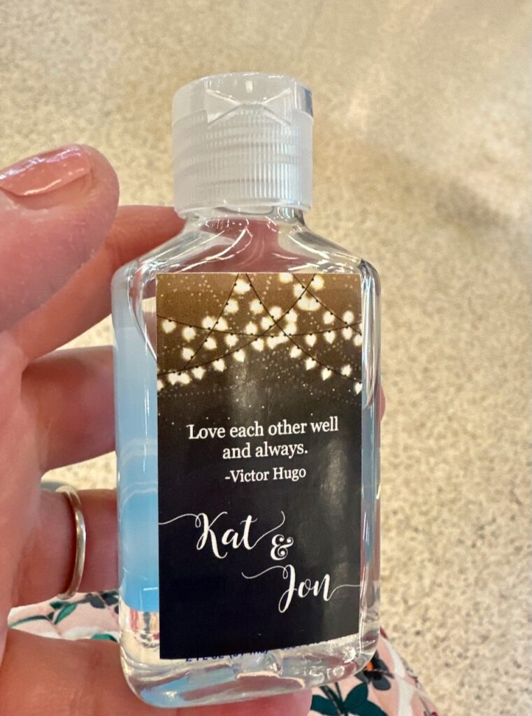 This is a wedding gift favor travel hand sanitizer bottle that has a Victor Hugo quote on it that says, "Love each other well and always" plus Kat and Jon to show life cycle of a plastic bottle.