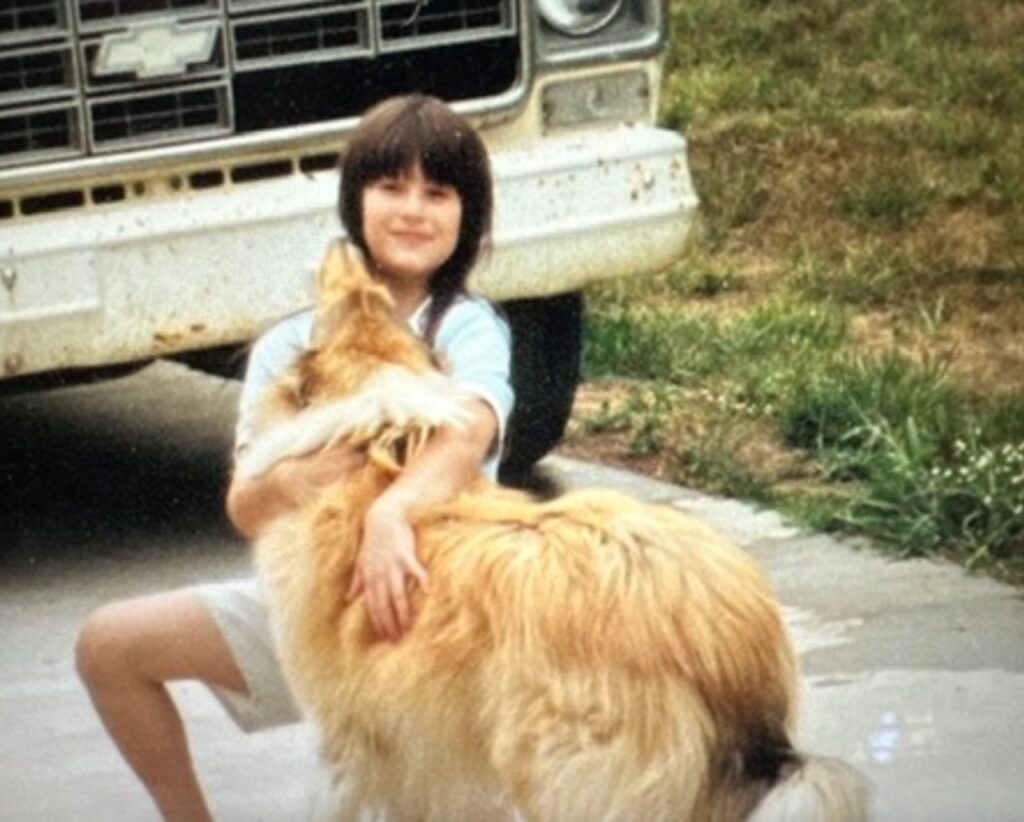 This is Kat as a kid hugging her collie dog to show how to increase firefly population by teaching kids kindness.